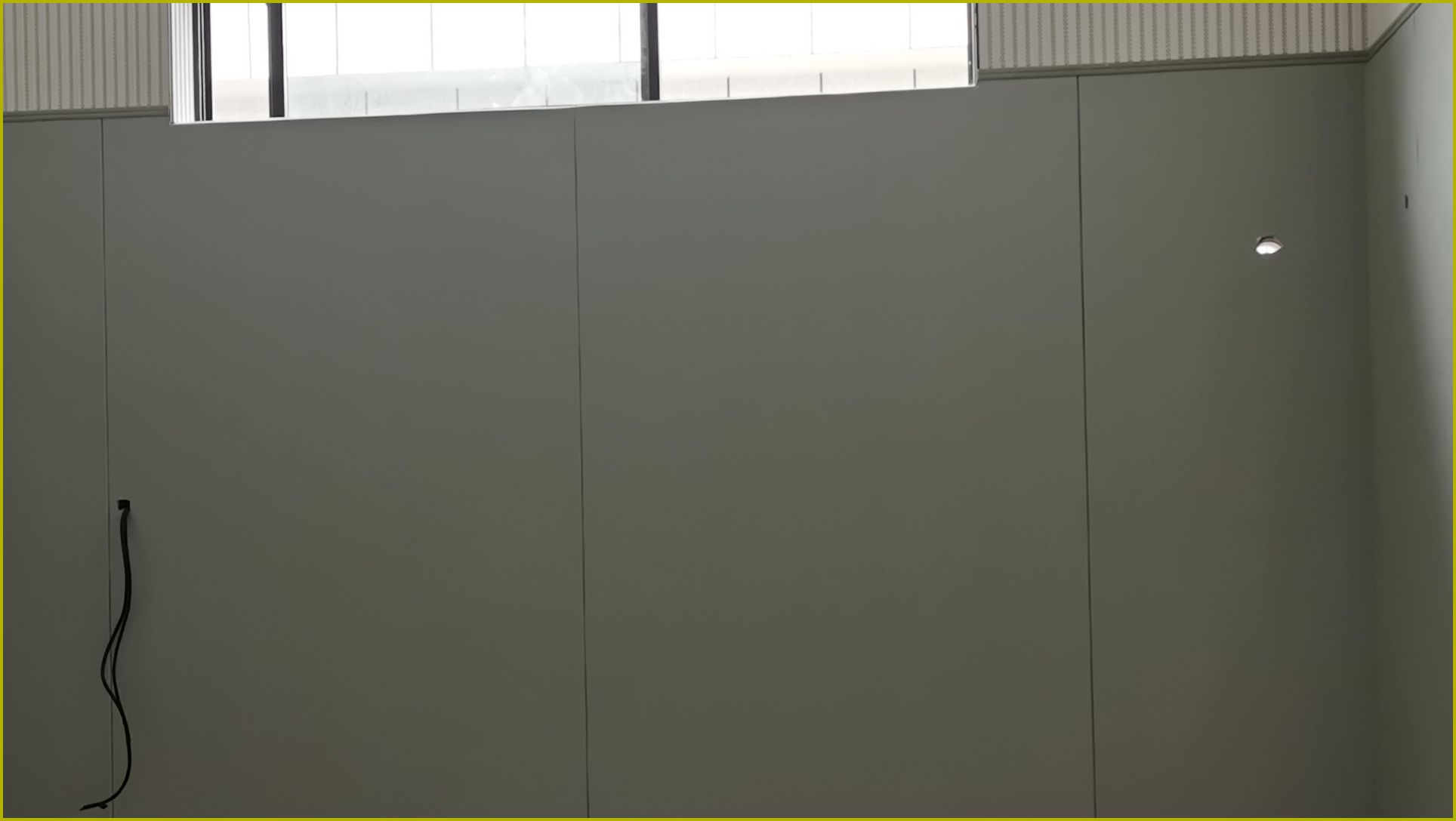 办案区审讯室灰色防撞软包墙面与白色木条吸音板安装实景，高密度海绵软包防自伤设计
